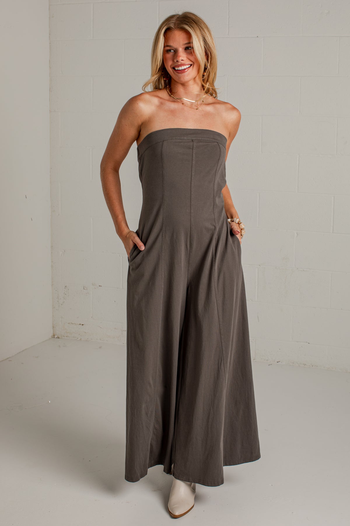 A dark gray strapless wide-leg jumpsuit with side pockets