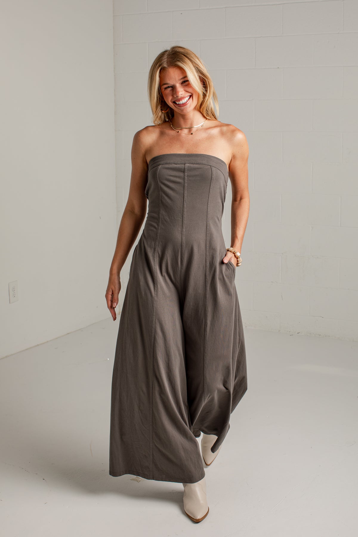 A dark gray strapless wide-leg jumpsuit with side pockets
