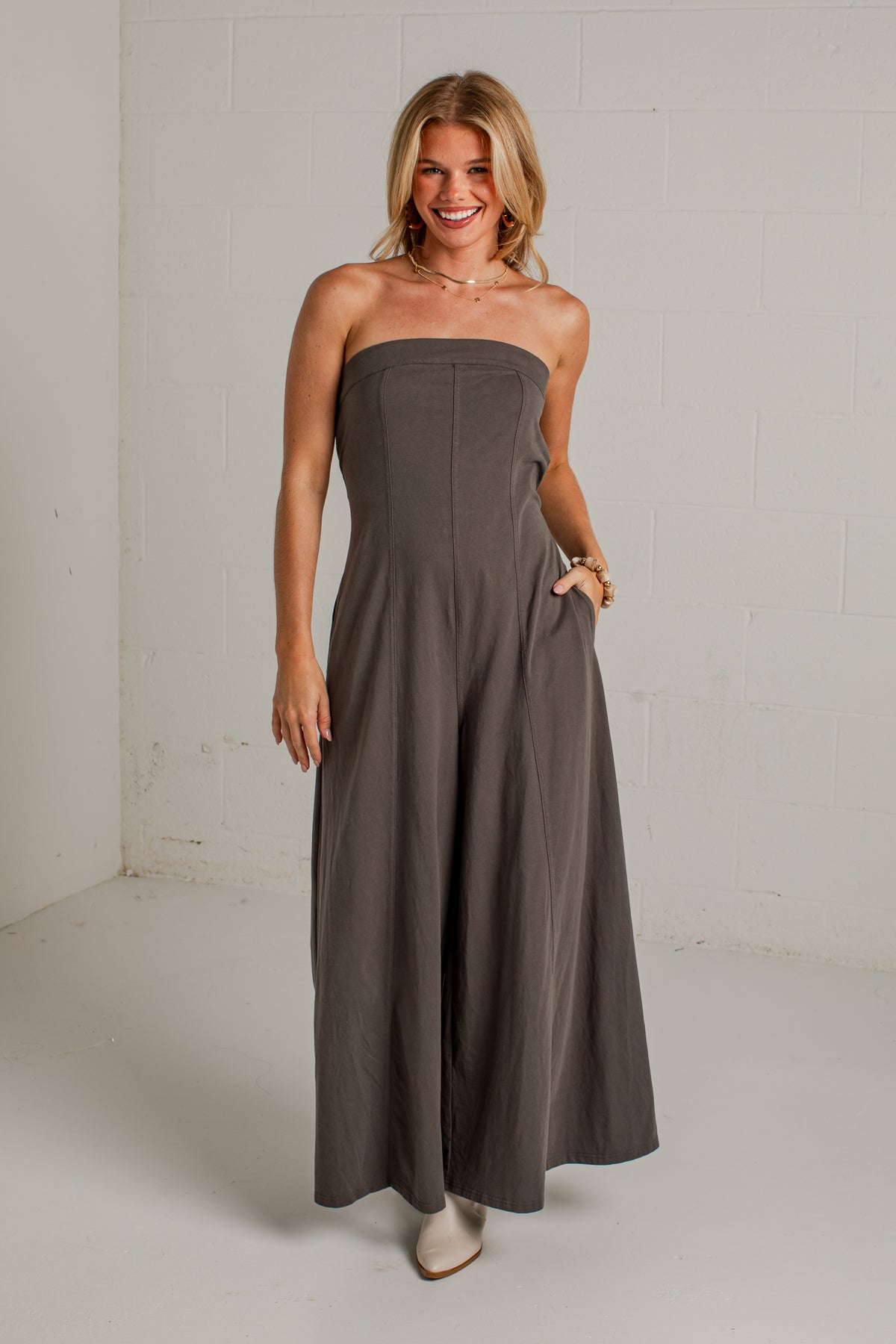 A dark gray strapless wide-leg jumpsuit with side pockets