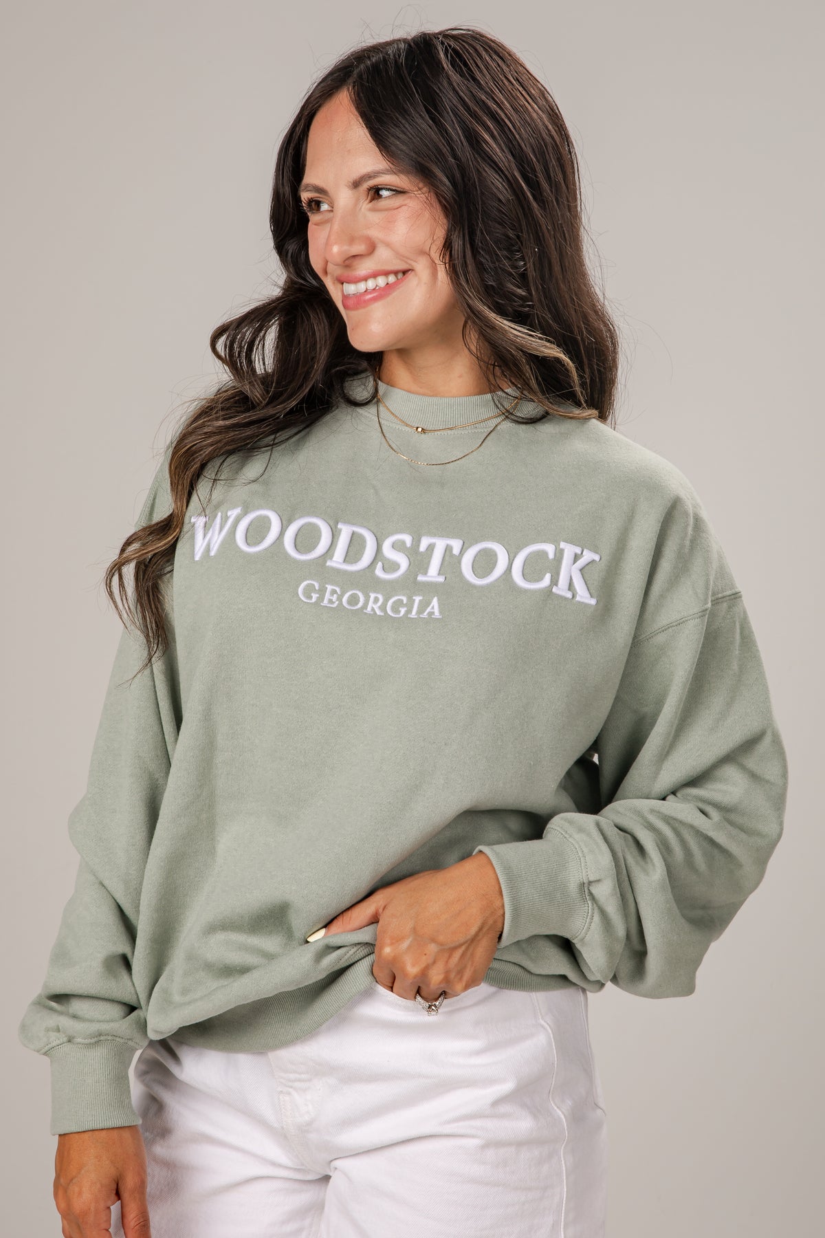 Woman wearing a green sweatshirt with &