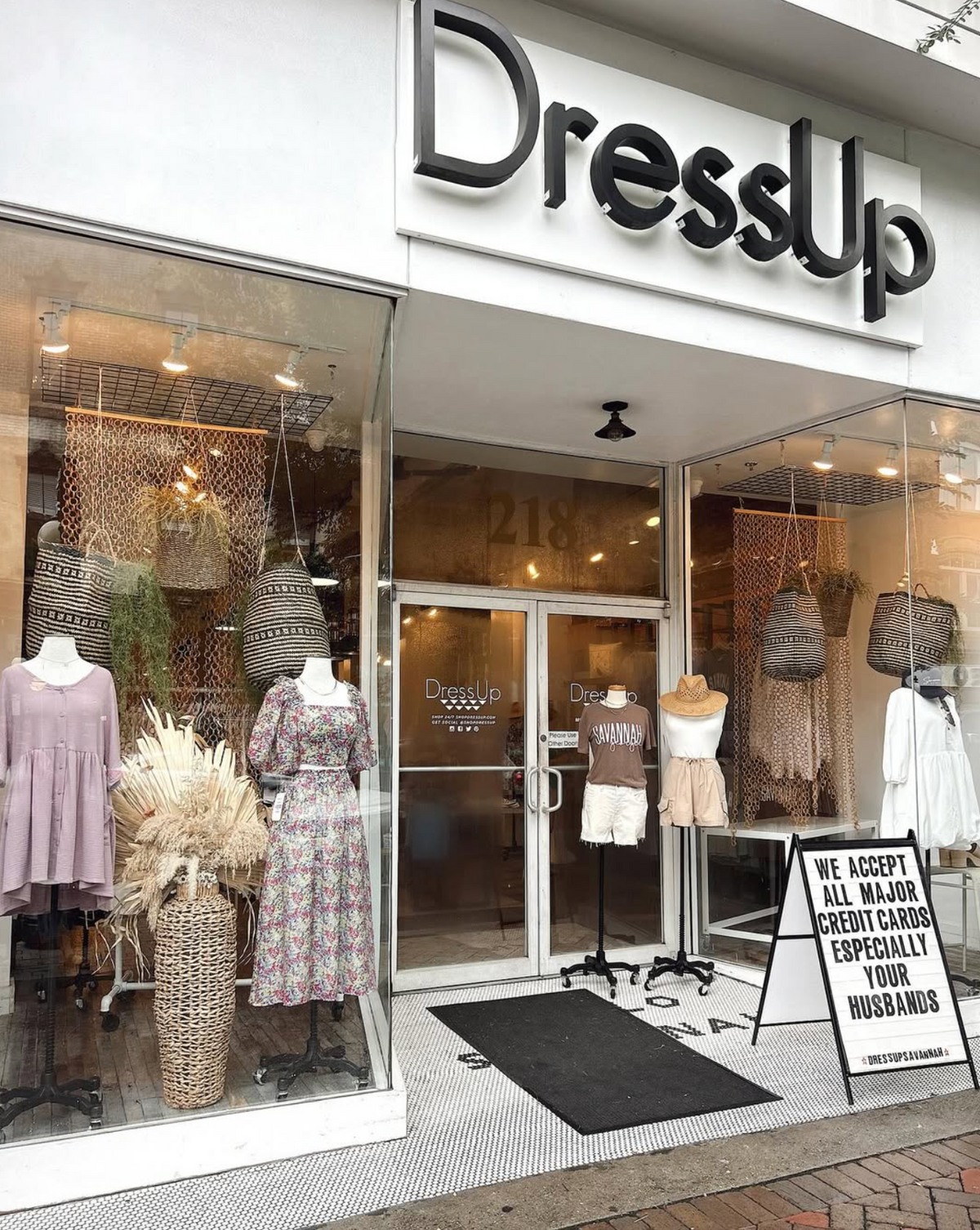 Storefront of a clothing store named 'DressUp' with mannequins and clothing displayed.