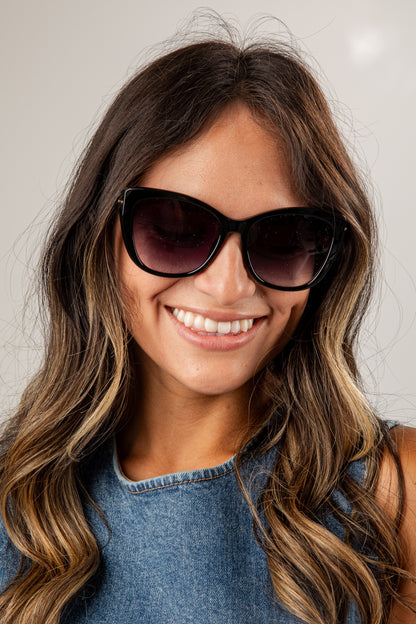 Woman wearing sunglasses with a neutral background