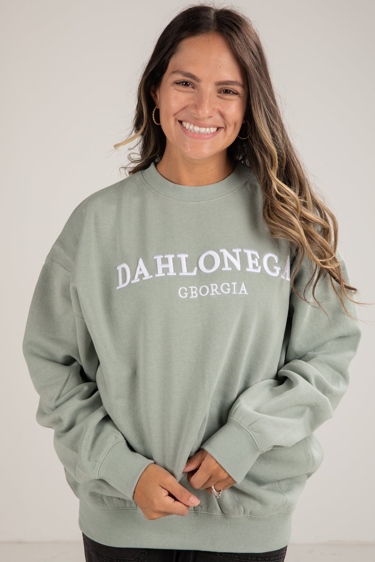 Woman wearing a green sweatshirt with &