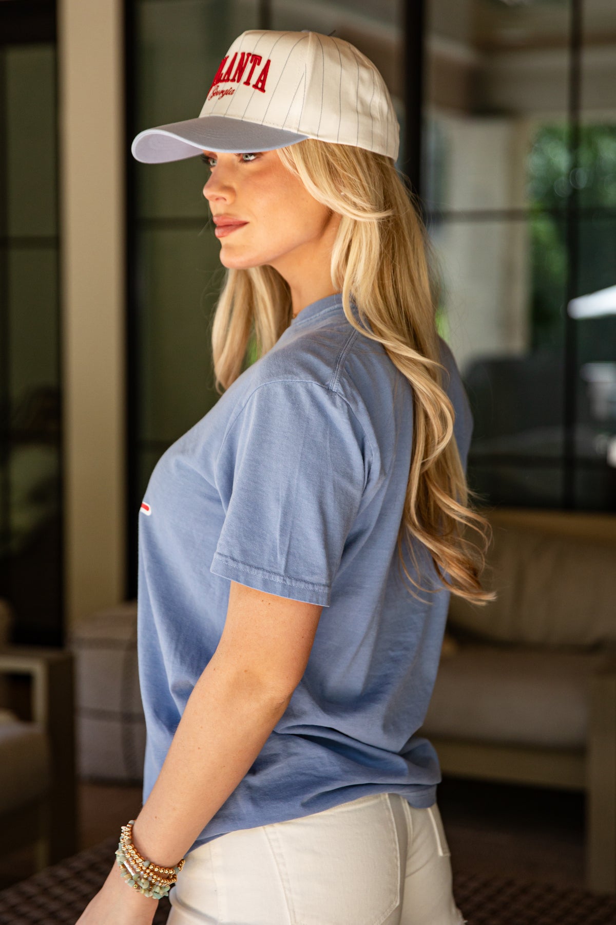 Woman wearing a blue shirt and white cap with &