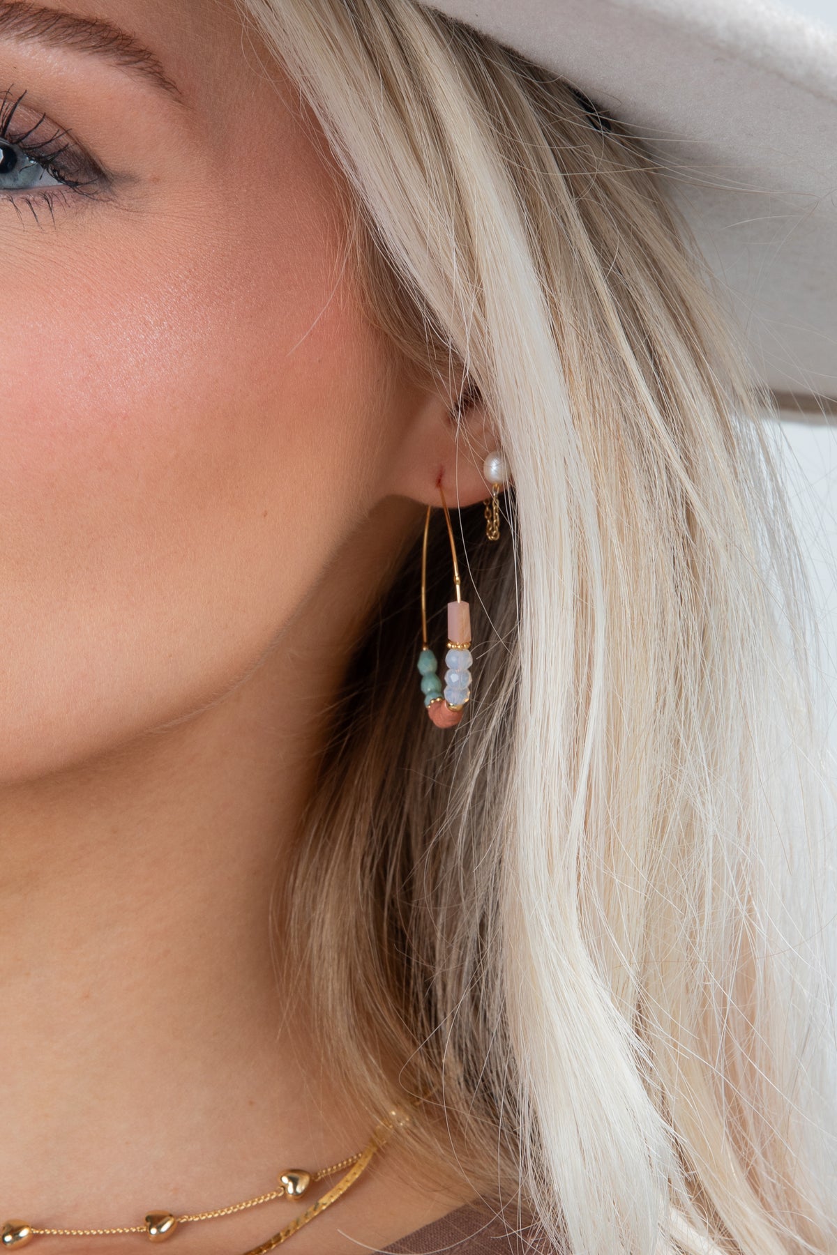 Close-up of a person wearing a beaded earring with a blurred background