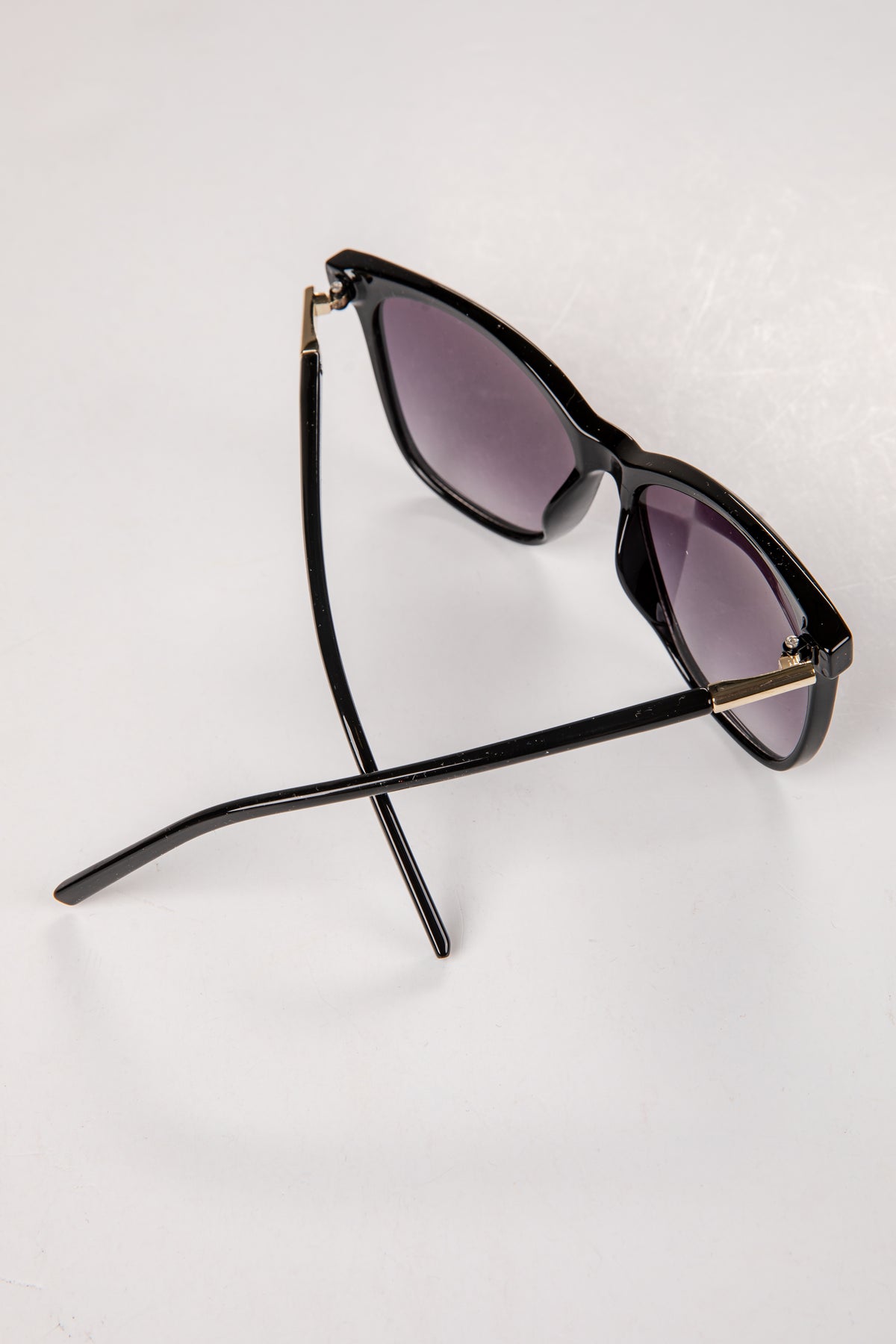Black sunglasses with purple lenses on a white background