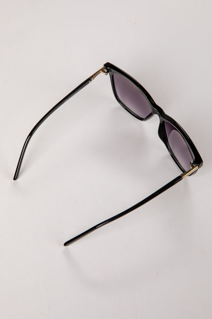Black sunglasses with gold accents on a white background