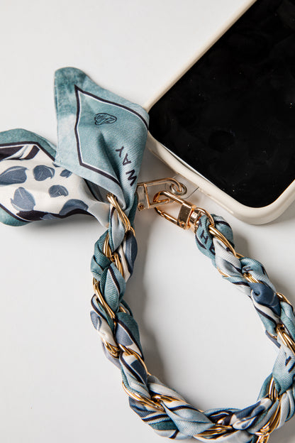 Phone case with a blue and white striped scarf accessory on a white background