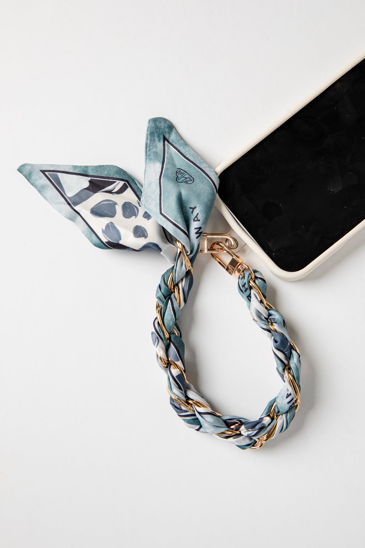 Phone case with a blue and white striped scarf accessory on a white background