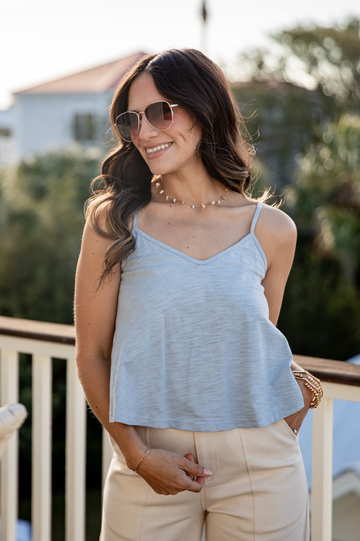 Woman wearing a light blue top and beige pants outdoors