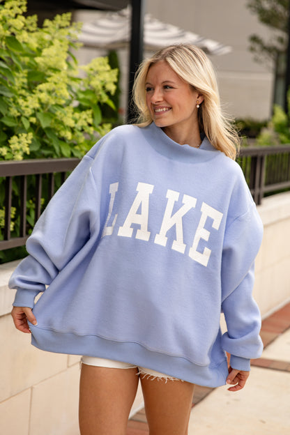 Woman wearing a light blue sweatshirt with &