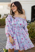 Woman wearing a floral off-shoulder dress outdoors.