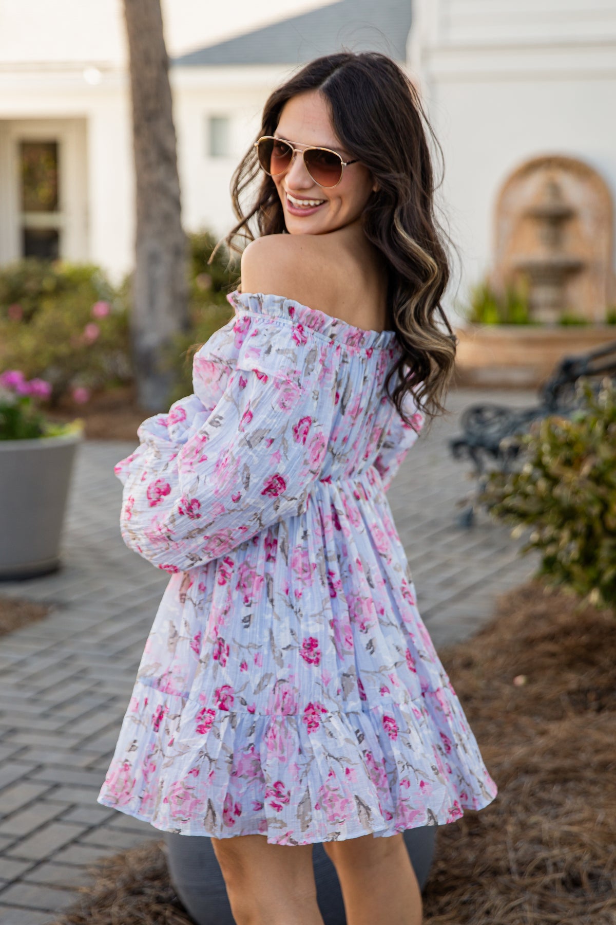 Woman wearing a floral off-shoulder dress in an outdoor setting