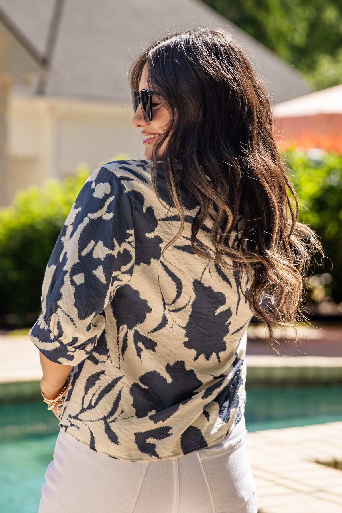 Woman wearing a floral blouse by a poolside