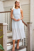 Woman in a light blue dress standing on a staircase.