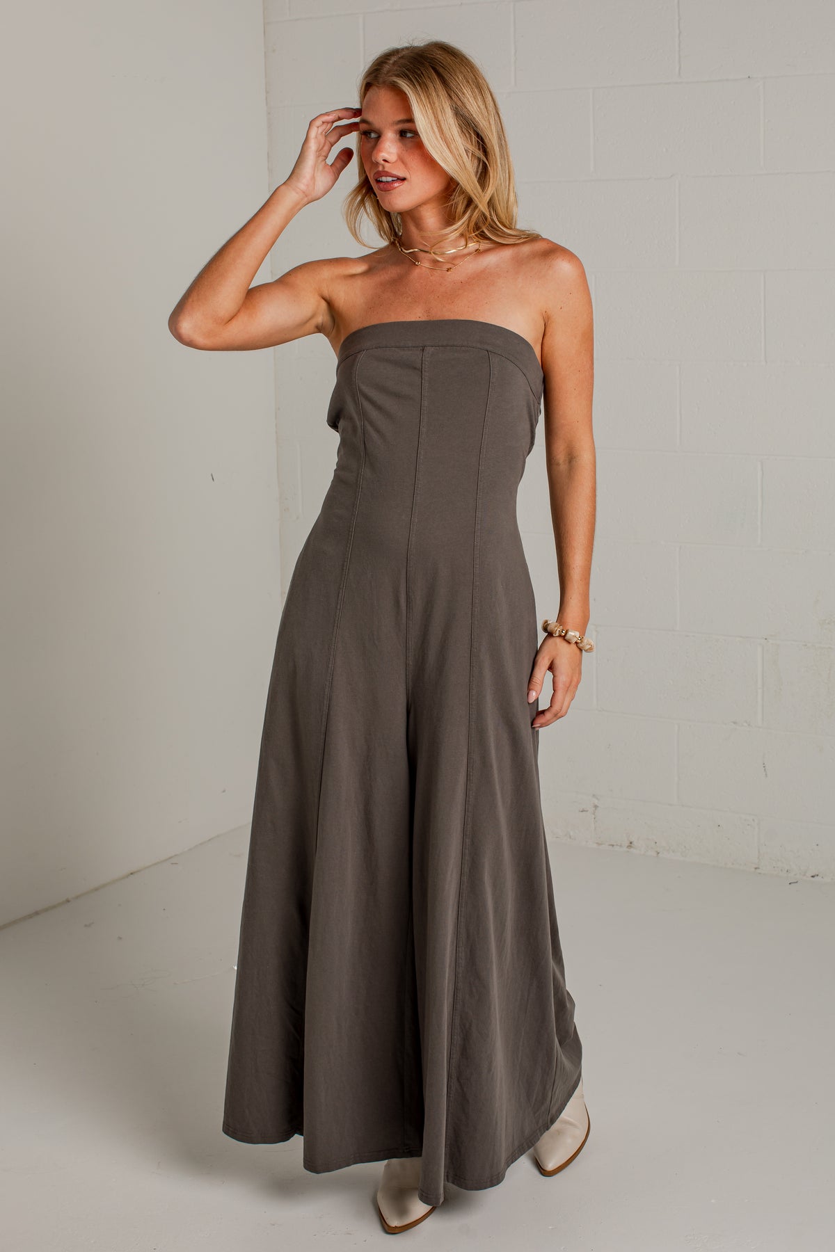 A dark gray strapless wide-leg jumpsuit with side pockets