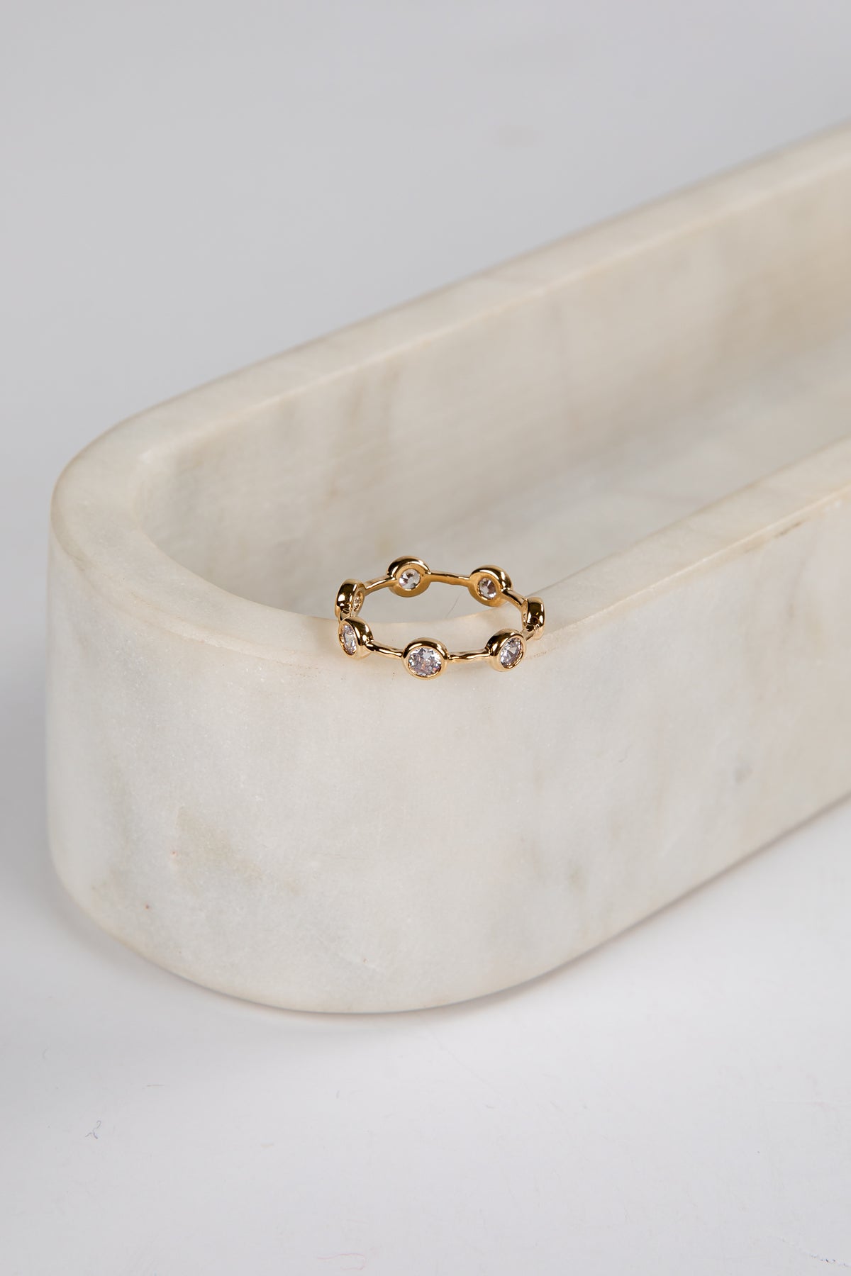 Gold ring with small stones on a marble surface