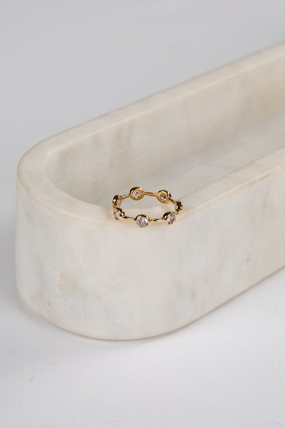Gold ring with small stones on a marble surface