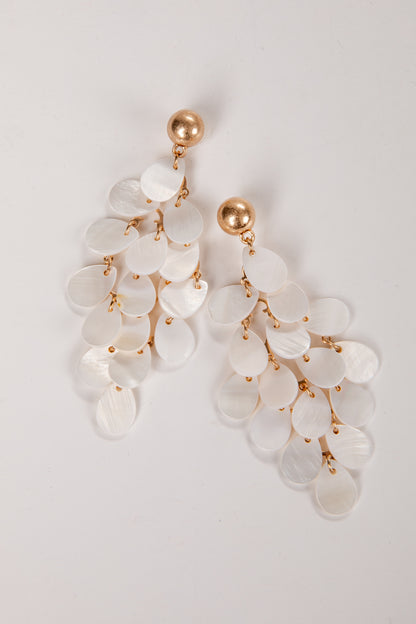 Elegant earrings with white stones and gold accents on a light gray background