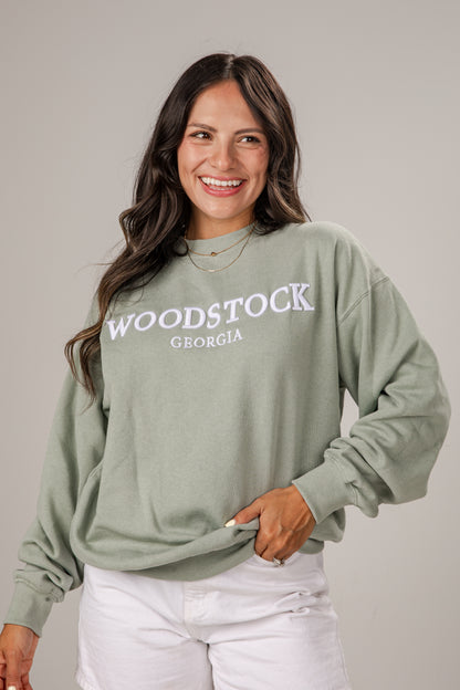 Woman wearing a green sweatshirt with &