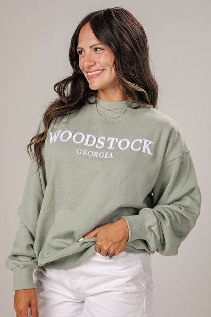 Woman wearing a green sweatshirt with &