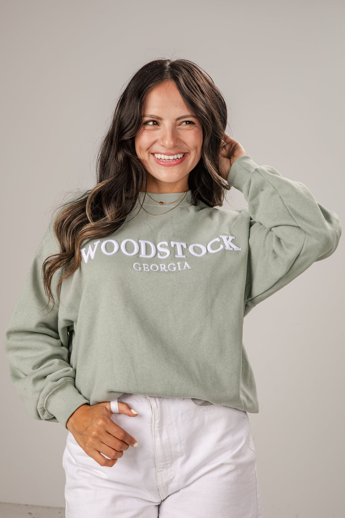 Woman wearing a green sweatshirt with &