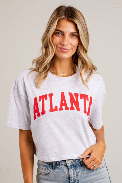 A woman wearing a light heather gray cropped t-shirt with &
