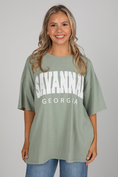 Woman wearing a green t-shirt with &