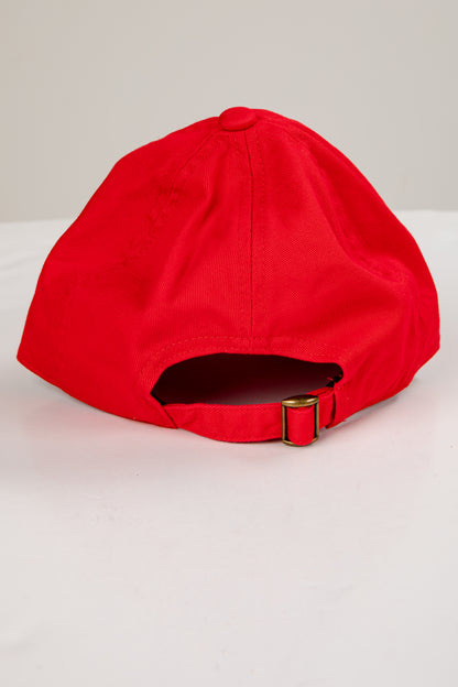 Red cap with a gold buckle on a light gray background