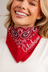A smiling blonde woman wearing a red bandana with a white and black paisley pattern and the word &