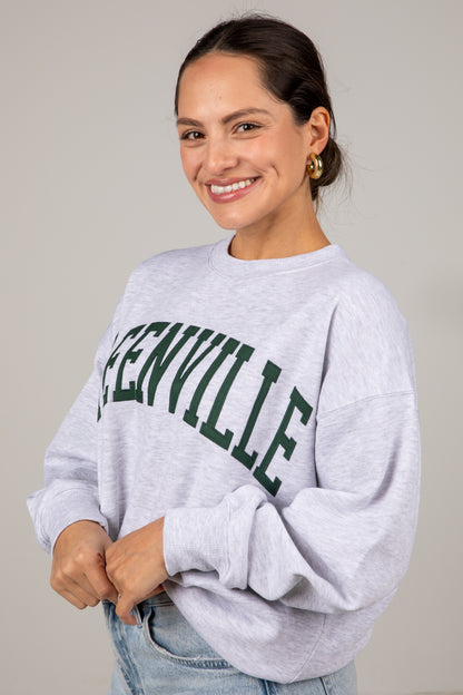 Woman wearing a gray sweatshirt with &