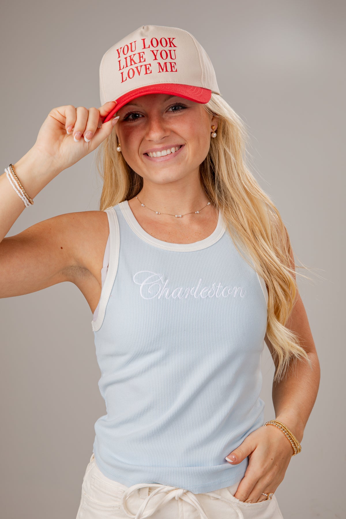 Woman wearing a light blue tank top with &