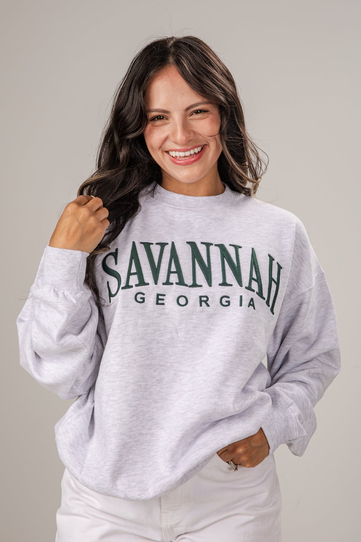 Woman wearing a gray sweatshirt with &