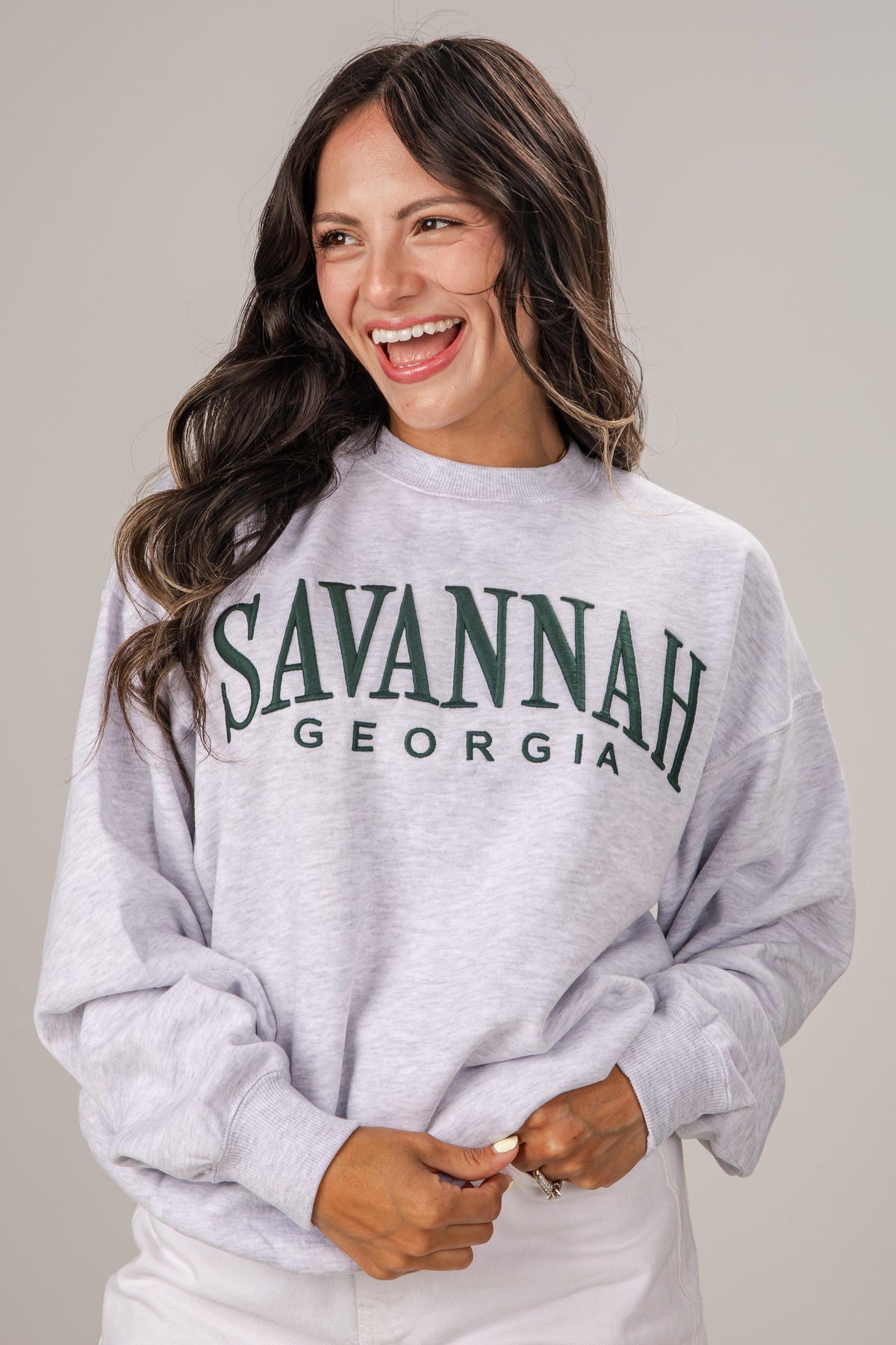 Woman wearing a gray sweatshirt with &