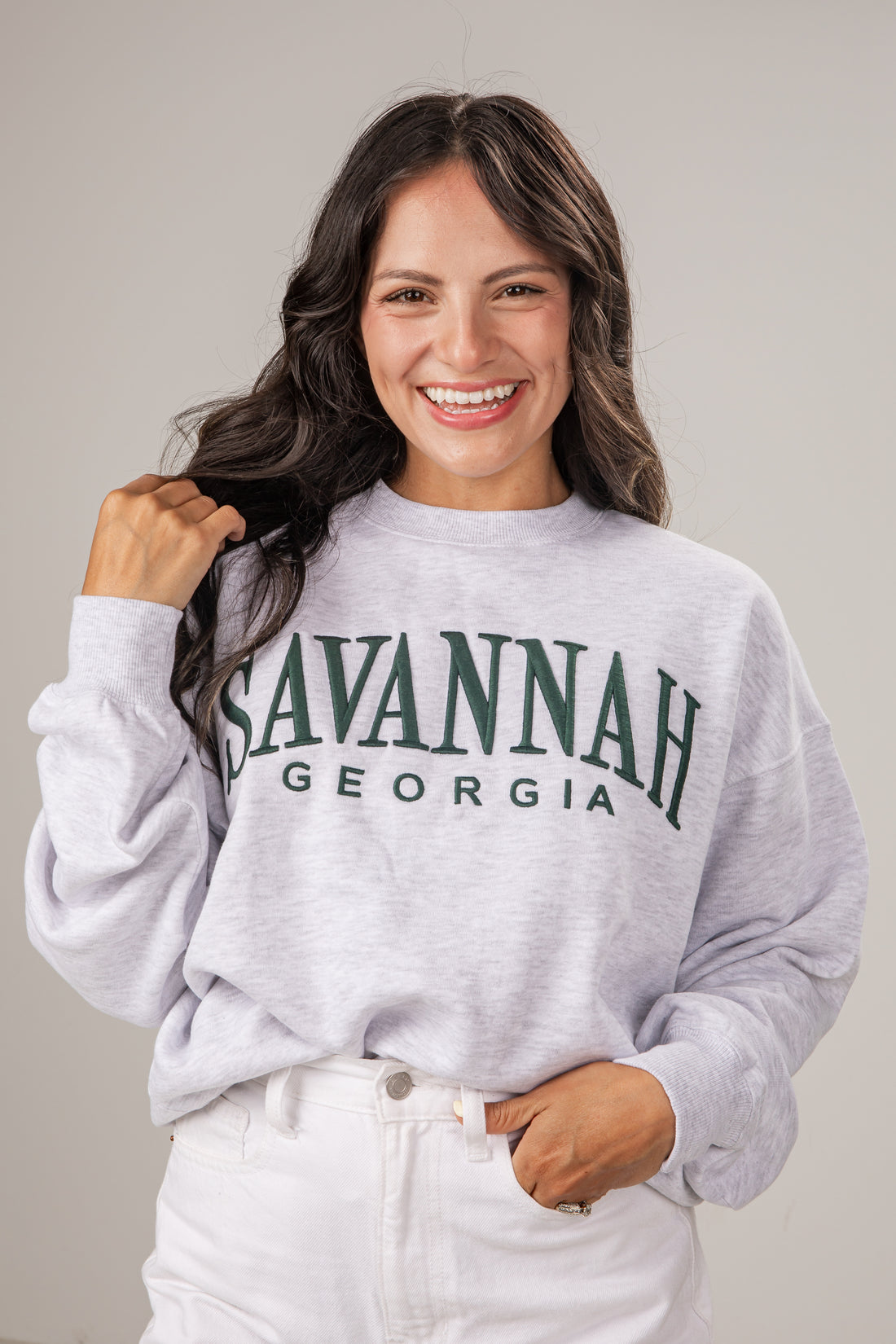 Woman wearing a gray sweatshirt with &