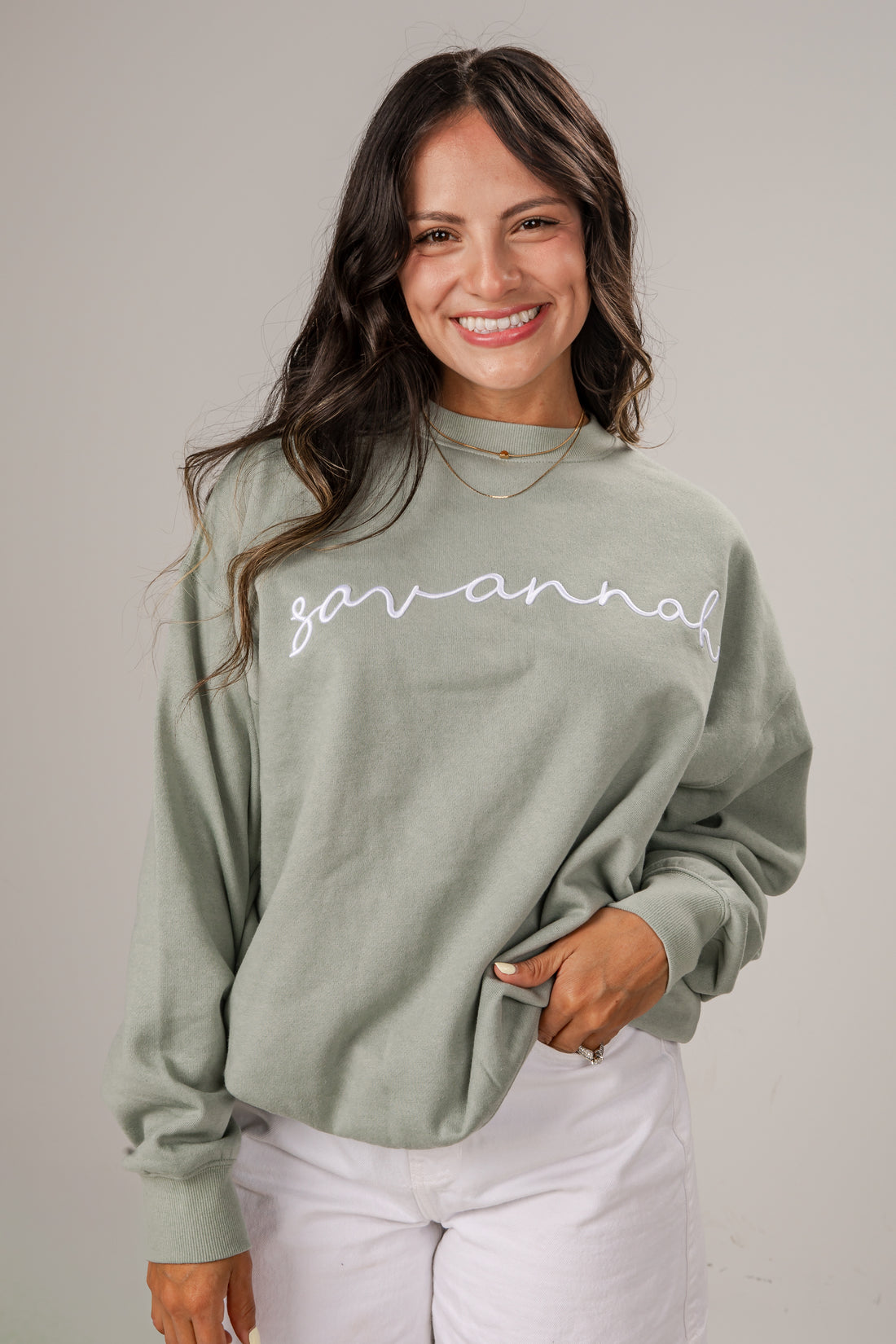 Woman wearing a green sweatshirt with &