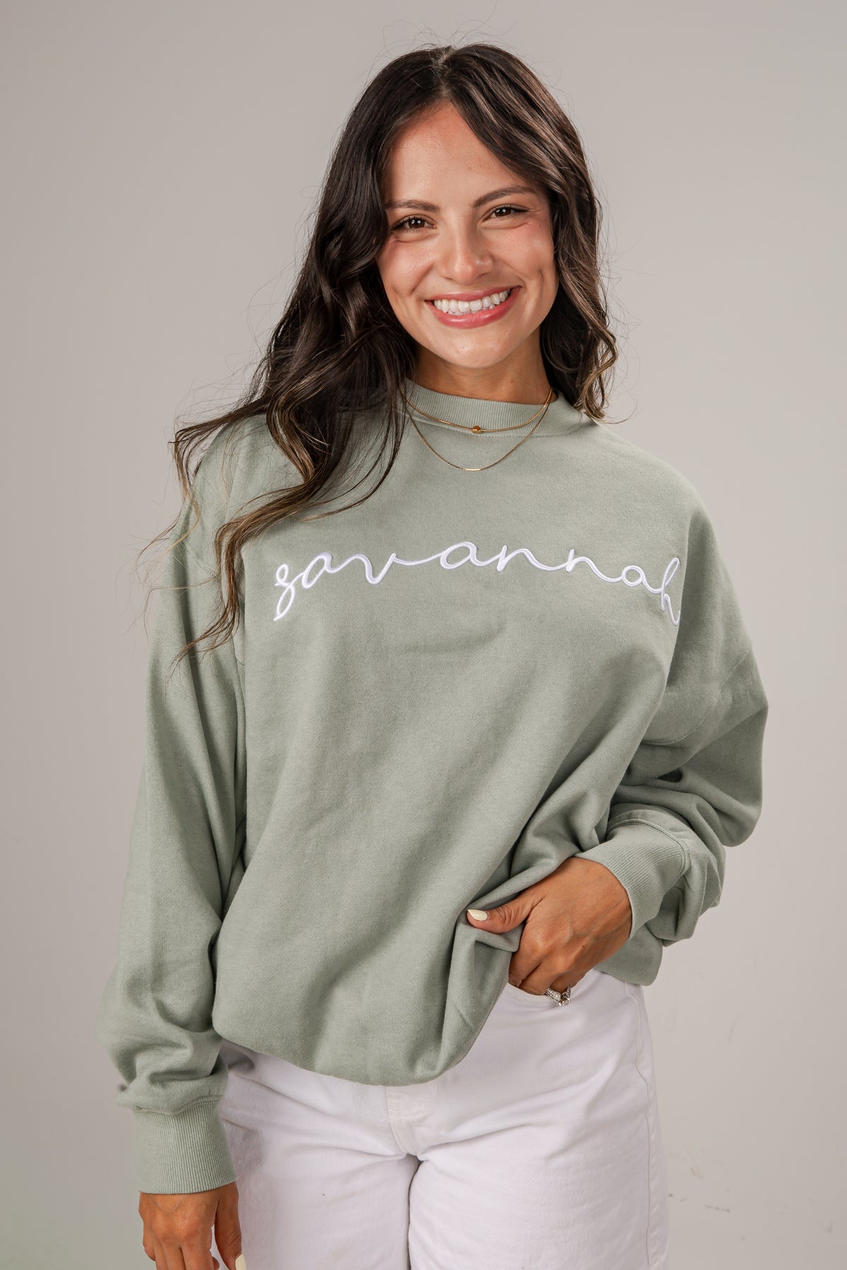 Woman wearing a green sweatshirt with &