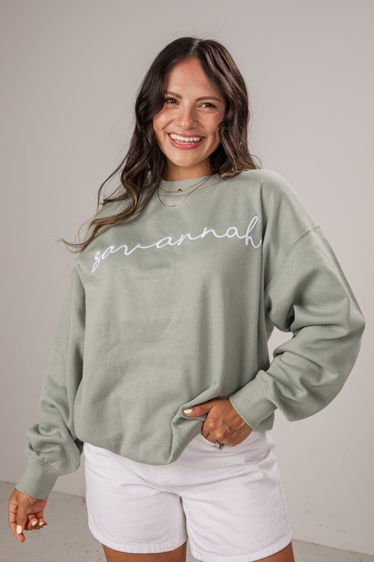 Woman wearing a green sweatshirt with &