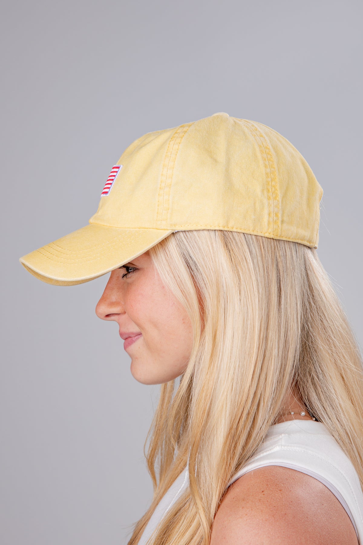 Woman wearing a yellow cap on a gray background