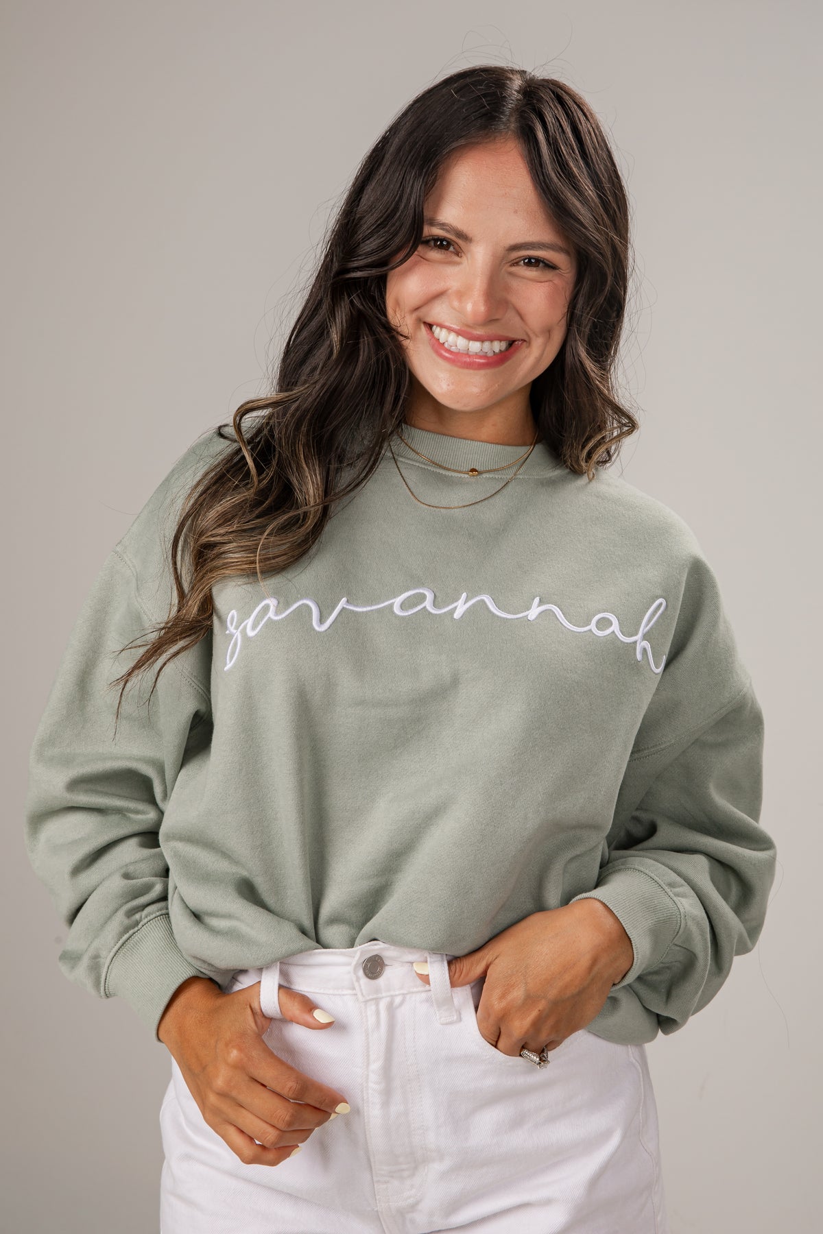 Woman wearing a green sweatshirt with &