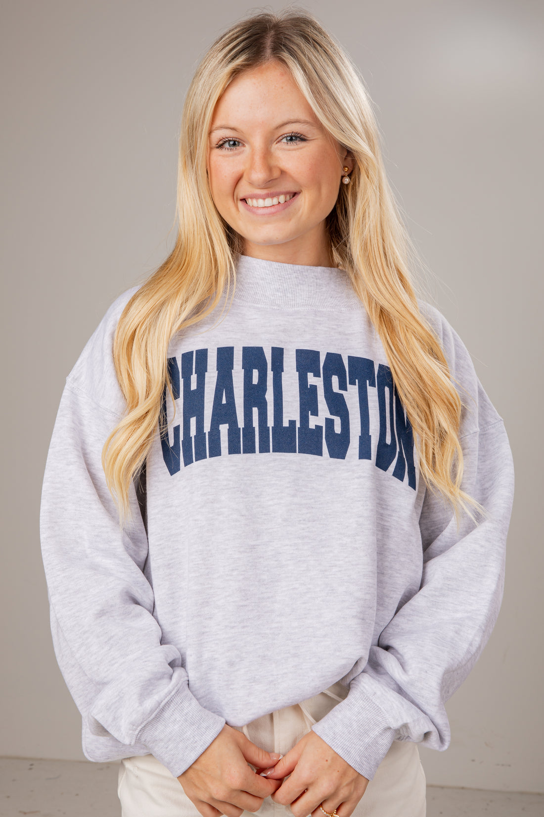 Woman wearing a gray sweatshirt with &