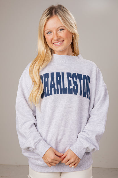 Woman wearing a gray sweatshirt with &