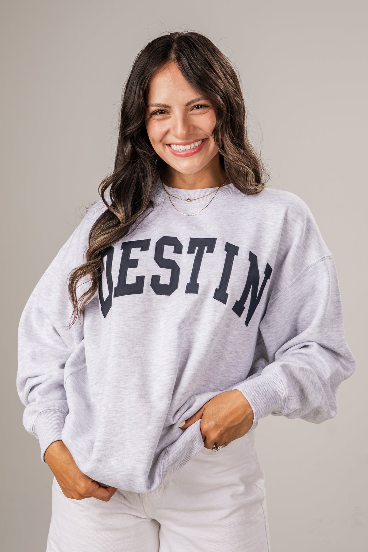 Woman wearing a gray sweatshirt with &