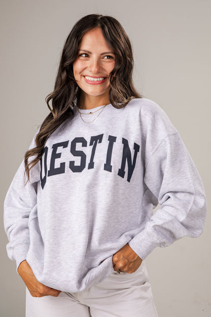 Woman wearing a gray sweatshirt with &