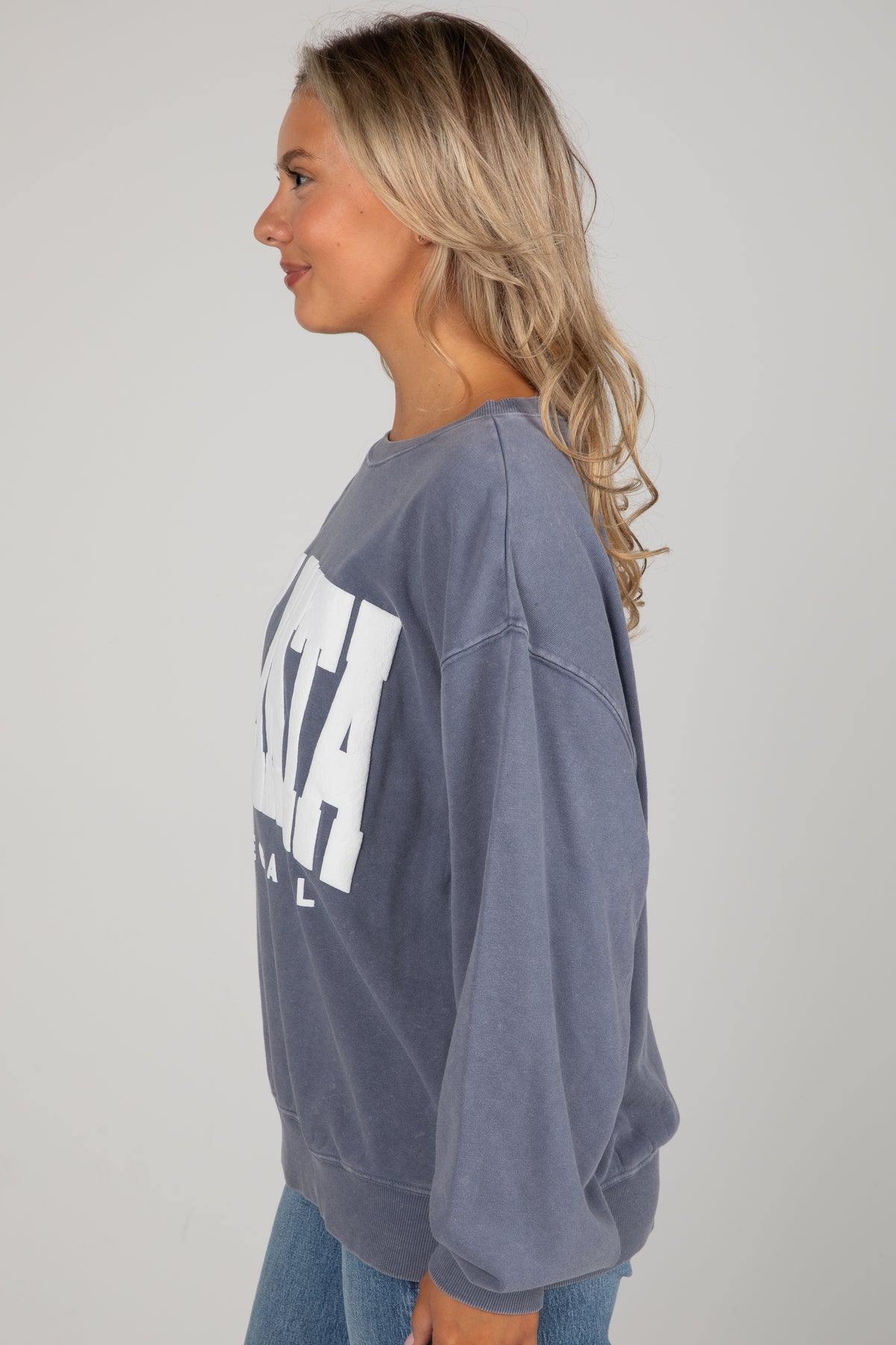 Woman wearing a gray sweatshirt with &