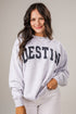 Woman wearing a gray sweatshirt with &