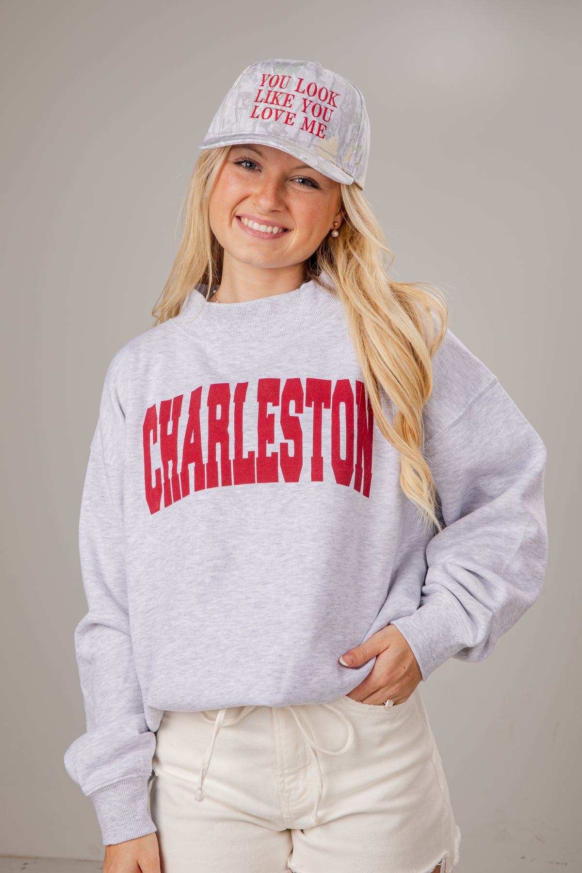 Person wearing a gray sweatshirt with &