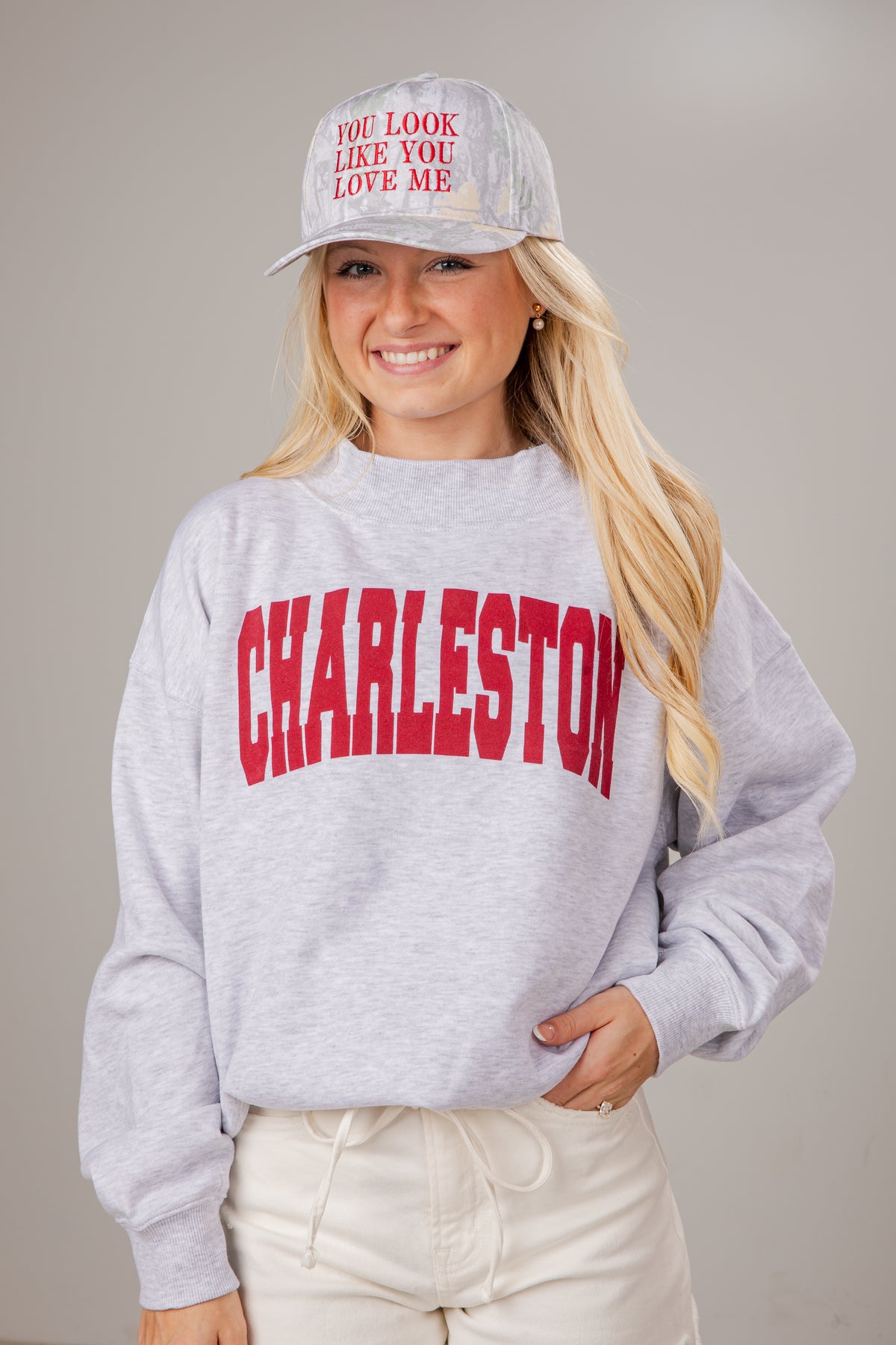 Woman wearing a gray sweatshirt with &
