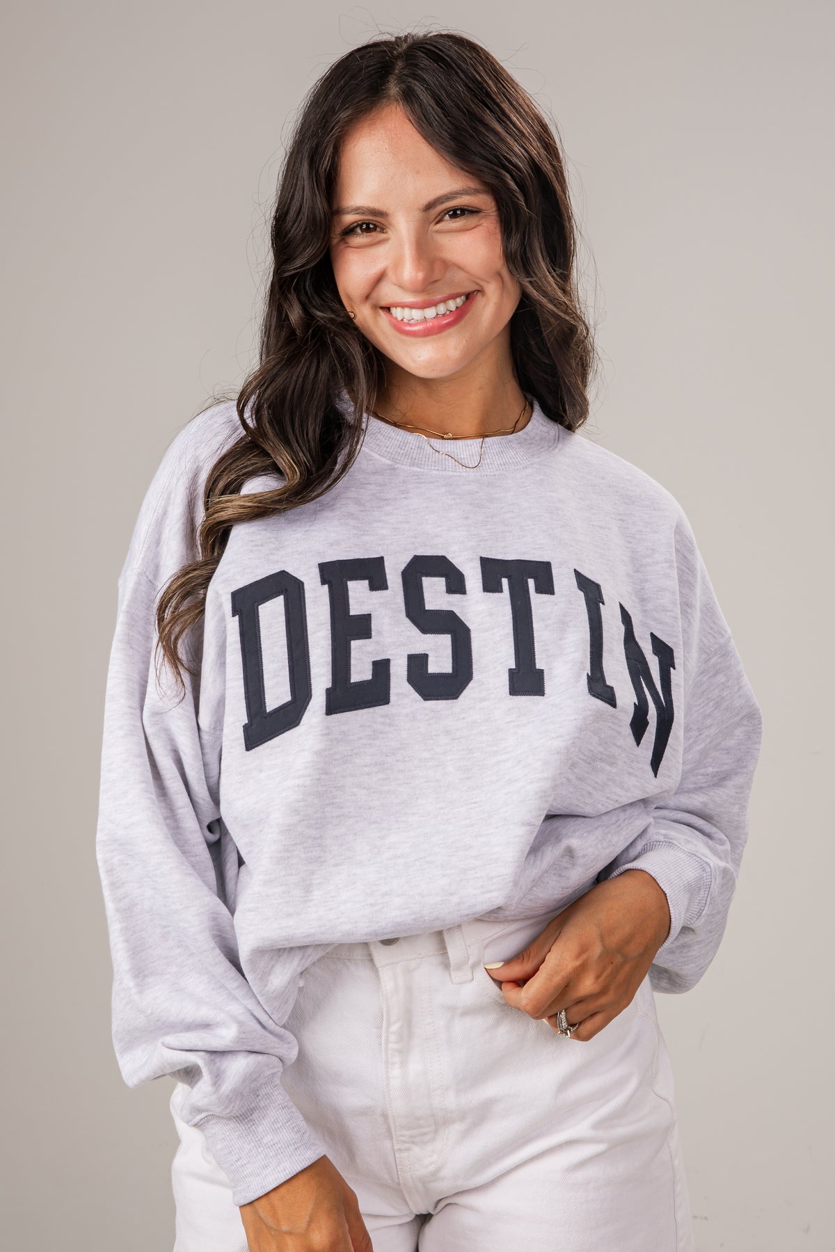 Woman wearing a gray sweatshirt with &