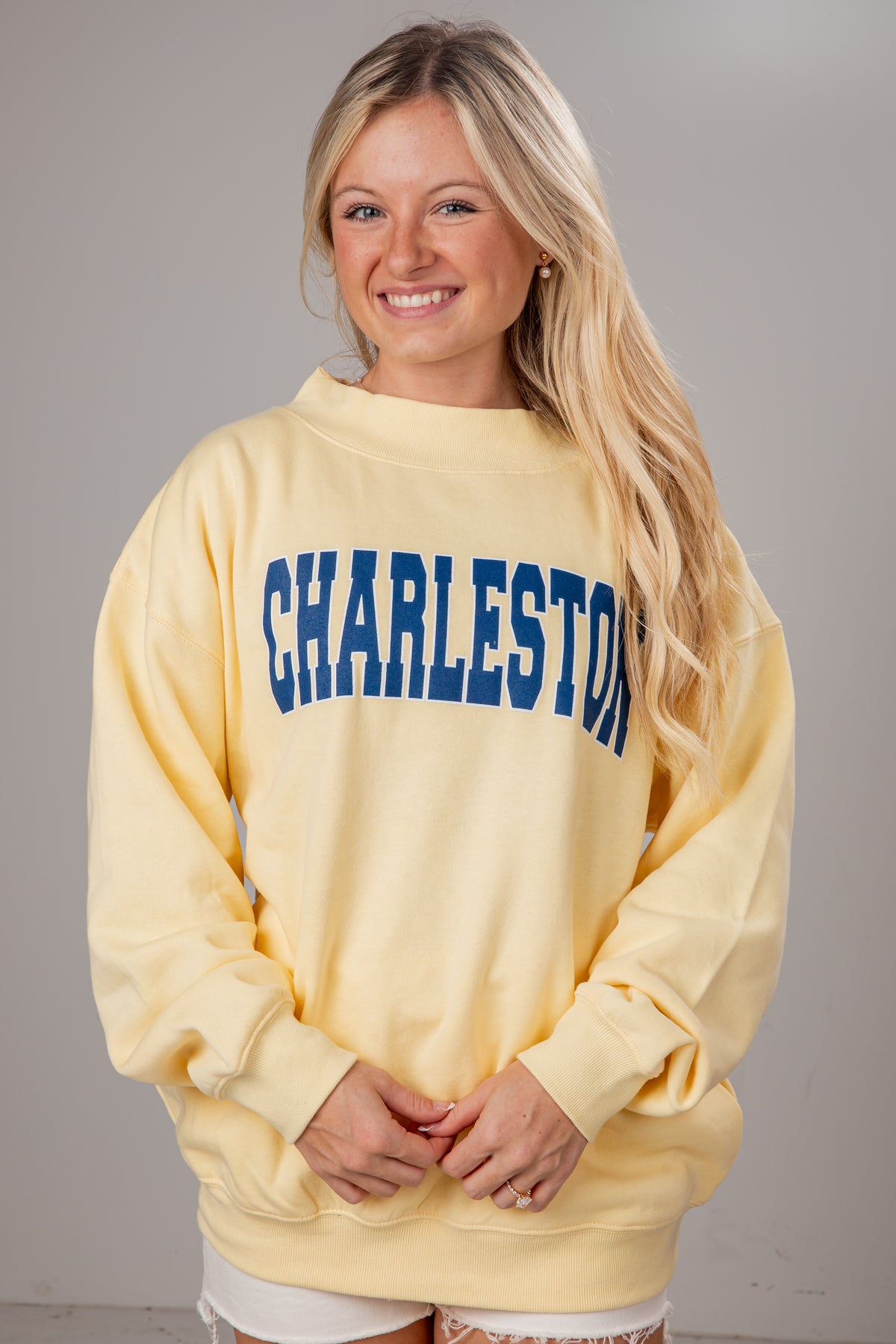 Woman wearing a yellow sweatshirt with &